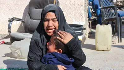 امرأة في غزة تحتضن طفلها