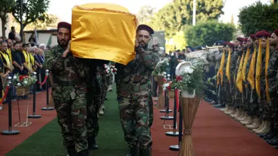 عناصر من "حزب الله" يشيعون أحد قتلى الغارات الإسرائيلية