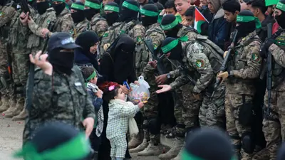 طفل يقدم الحلوى لمقاتلي حماس في النصيرات