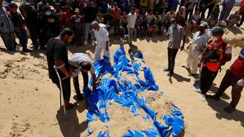 مواطنون فلسطينيون يشاركون في دفن جثث في غزة