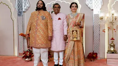 العريس أنانت أمباني يلتقط صورًا مع نيتا أمباني وموكيش أمباني على السجادة الحمراء