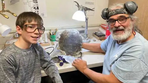 الطفل مع الأحفورة التي عثر عليها