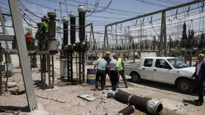 عمال يصلحون شبكة كهرباء في سوريا