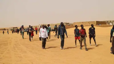 أحد موظفي منظمة أطباء بلا حدود يرافق أشخاصًا عبروا الصحراء سيرًا على الأقدام إلى النيجر بعد طردهم من الجزائر. 