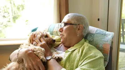 كبيرة في السن تحتضن كلبها الأليف