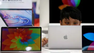 طفل ينظر إلى أجهزة "ماك" المعروضة