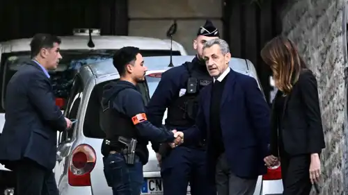 ساركوزي يصافح ضابط شرطة لدى مغادرته مقر إقامته