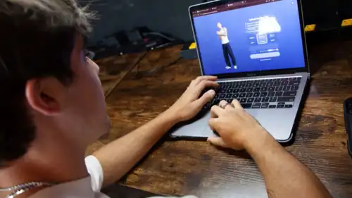 مراهق يجلس أمام كمبيوتر محمول