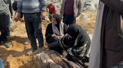 سيدة تتفحص أحد الجثامين