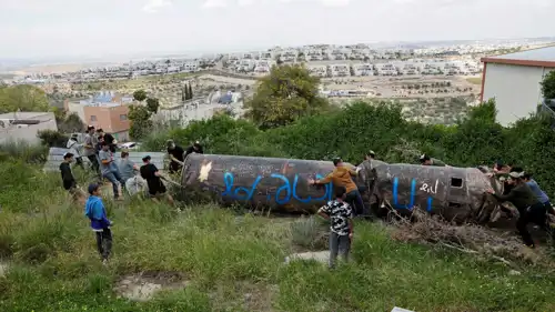 إسرائيليون يسحبون حطام صاروخ إيراني قرب مستوطنة "بدوئيل"