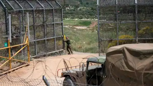 جندي إسرائيلي يفتح بوابة على الحدود بين مرتفعات الجولان المحتلة وسوريا