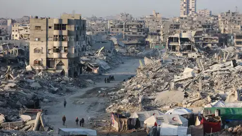 فلسطينيون بين أنقاض مبان مدمرة في حي الشيخ رضوان