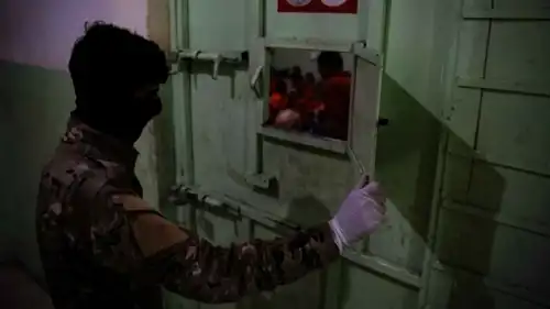 حارس يعاين سجناء داعش في سجن الرقة المركزي