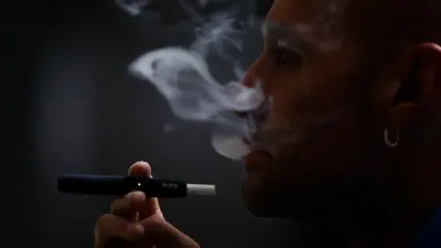 رجل يدخن على جهاز iQOS