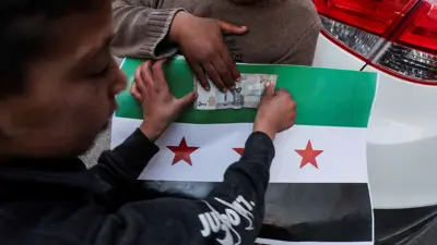 طفل يبيع العلم السوري الجديد