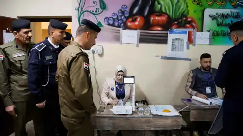 أحد أفراد الأمن يستعد للتصويت في انتخابات العراق