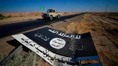 لافتة سوداء تابعة لمسلحي تنظيم "داعش" على الطريق في مطار الفاتحة العسكري جنوب الحويجة بالعراق