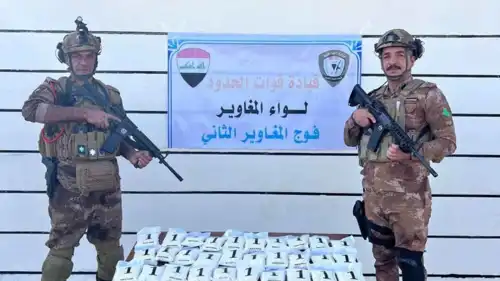 جنديان عراقيان بجوار مخدرات تم إحباط تهريبها من سوريا