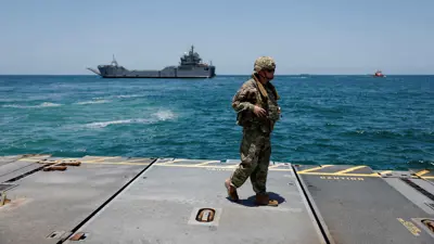 جندي يقف عند رصيف توصيل المساعدات قبالة قطاع غزة