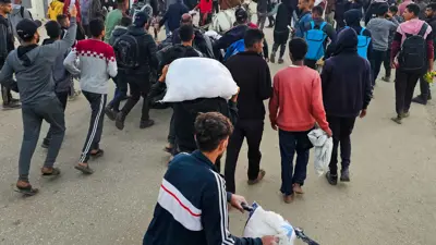 فلسطينيون يحملون مساعدات في غزة