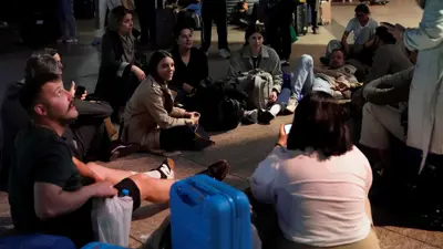 مسافرون يفترشون الأرض بعد انقطاع الكهرباء بمحطة قطارات مدريد