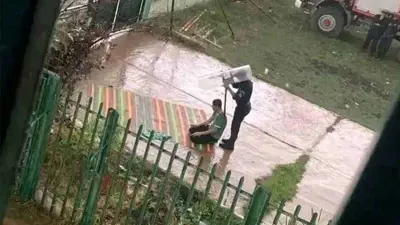 أحد أفراد الشرطة الجزائرية خلال حمايته لمشجع من الأمطار