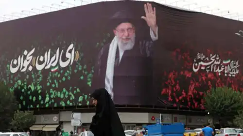 إيرانية تسير أمام لافتى لخامنئي في طهران