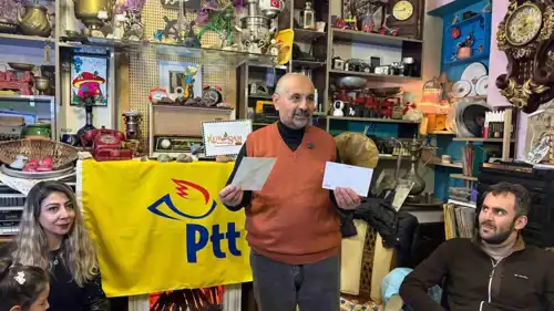 صاحب المقهى مع بطاقات المعايدة البريدية.