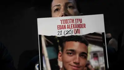 والدة عيدان ألكسندر تمسك صورة لابنها