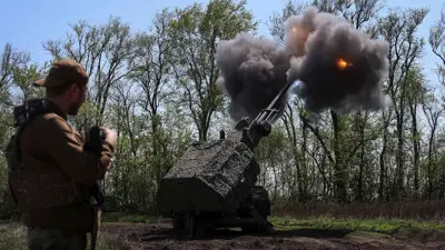 جندي أوكراني بالقرب من مدفع هاوتزر