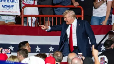 دونالد ترامب يلوّح خلال تجمع انتخابي في نيو هولاند أرينا