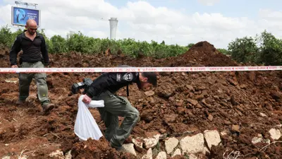 ضباط الشرطة الإسرائيلية يفحصون حفرة في موقع مطار بن غوريون