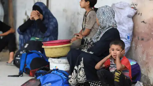 عائلة غزية نازحة خارج مستشفى بالقطاع