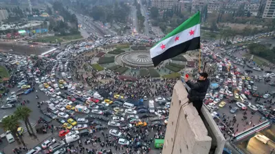 العلم السوري الجديد فوق ساحة الأمويين في دمشق