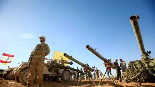 عنصر من حزب الله أمام قطع أسلحة تتبع للحزب 