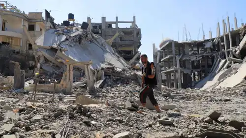 رجل فلسطيني يمشي وسط الدمار في قطاع غزة