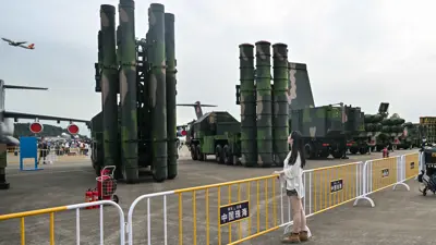 سيدة تشاهد عرضا لمنظومة الصواريخ الصينية HQ-19