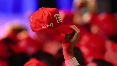  أحد المؤيدين يرفع قبعة ترامب