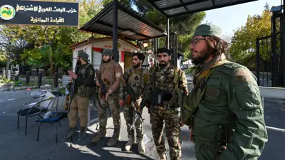 عناصر من الفصائل المسلحة تحرس مقر لحزب البعث