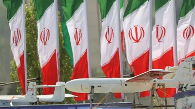 علم إيران وأمامه طائرات مسيرة