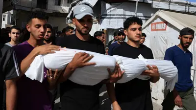 مدنيون من غزة يحملون جثمان طفل