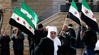 سكان دروز من قرية مجدل شمس في مرتفعات الجولان، التي ضمتها إسرائيل يلوحون بالأعلام السورية أثناء مشاركتهم في مظاهرة 