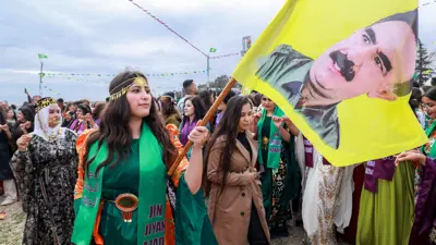 فتاة تحمل صورة أوجلان خلال فعالية نسائية في القامشلي