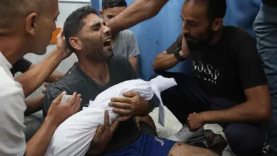 فلسطيني يحمل جثمان طفله في غزة