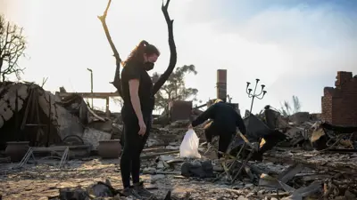 امرأة تقف عند بقايا منزلها الذي دمره الحريق في لوس أنجلوس