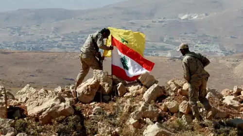 مقاتلون من حزب الله يرفعون العلم اللبناني وعلم حزب الله