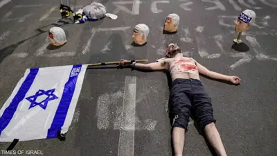 متظاهر إسرائيلي بجانب رؤوس نتنياهو المزيفة