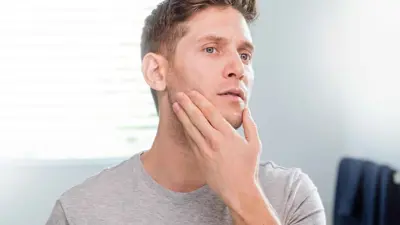 رجل يتفحص بشرته