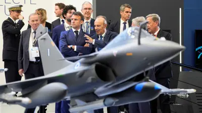 ماكرون بجانب نسخة من طائرة مقاتلة من طراز رافال