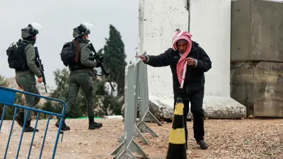 رجل فلسطيني يعبر حاجزًا للجيش الإسرائيلي في قلنديا بالضفة الغربية